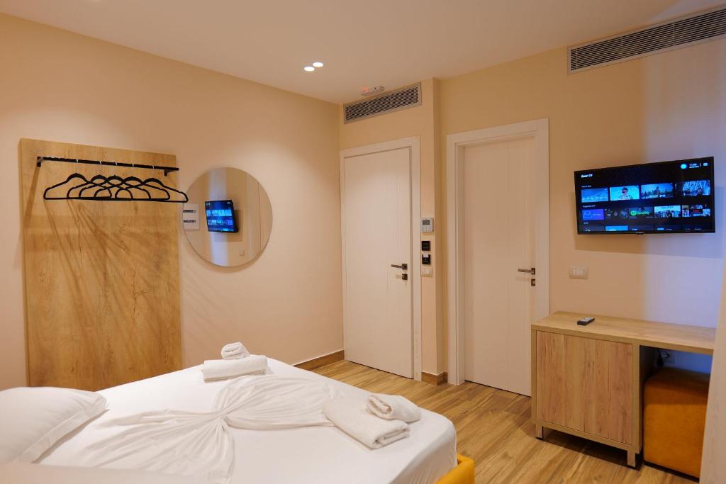 a bedroom with a bed and a flat screen tv at Hotel Alexander in Ksamil