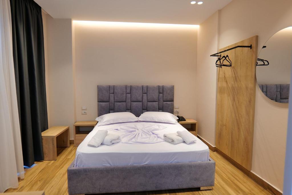 a bedroom with a bed with white towels on it at Hotel Alexander in Ksamil