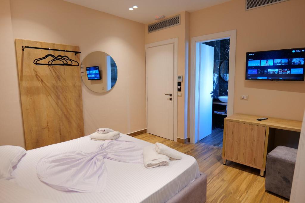 a bedroom with a bed with towels on it at Hotel Alexander in Ksamil