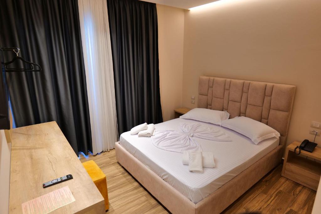 a bedroom with a large bed with two towels on it at Hotel Alexander in Ksamil