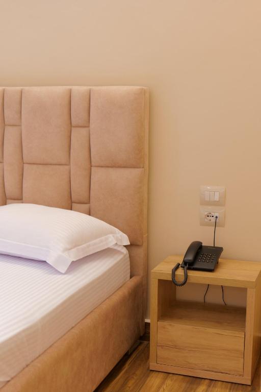 a bedroom with a bed and a phone on a table at Hotel Alexander in Ksamil