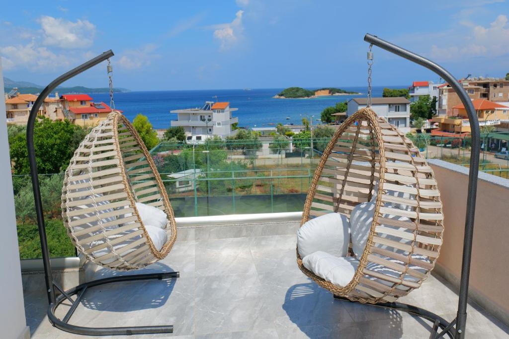 two chairs on a balcony with a view of the ocean at Hotel Alexander in Ksamil