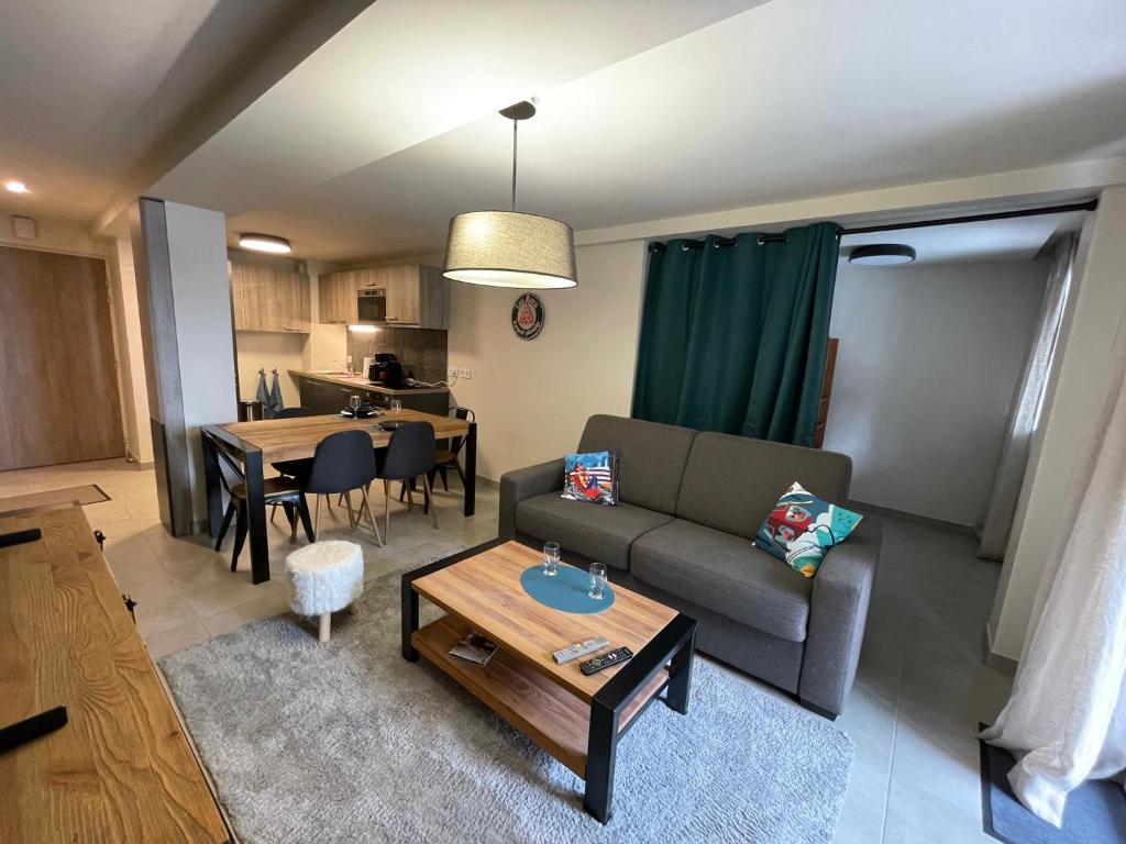 - un salon avec un canapé et une table dans l'établissement ARC 1800 Appartement 6-8 pers,5 cristaux, avec garage, à Arc 1800