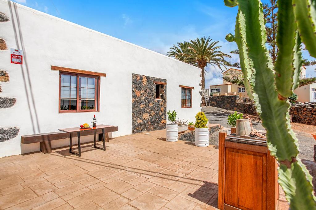 eine Terrasse mit einem Tisch und einem Gebäude in der Unterkunft Casa Domingo in Villaverde