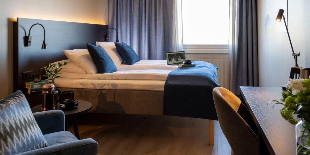 a bedroom with a large bed with blue pillows at Thon Partner Hotel Backlund in Levanger
