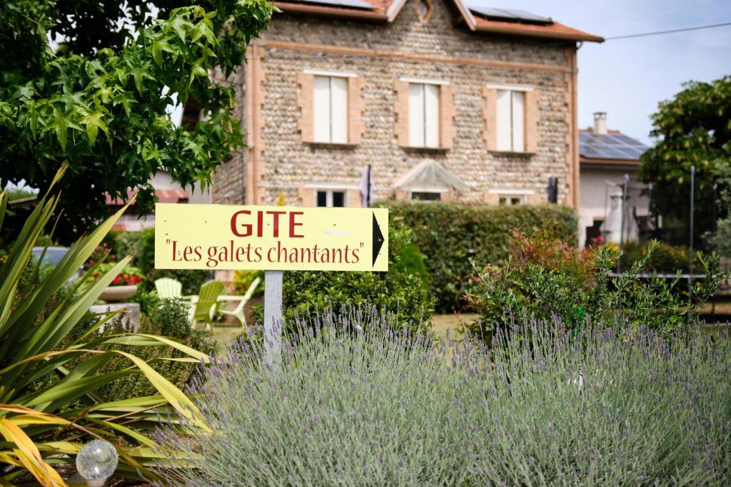 un cartel en un jardín frente a una casa en Gîte les Galets chantants, en Saint-Hilaire-du-Rosier
