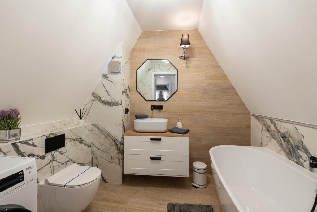 Łazienka z białą toaletą i umywalką w obiekcie Szafir Apartament w Kołobrzegu