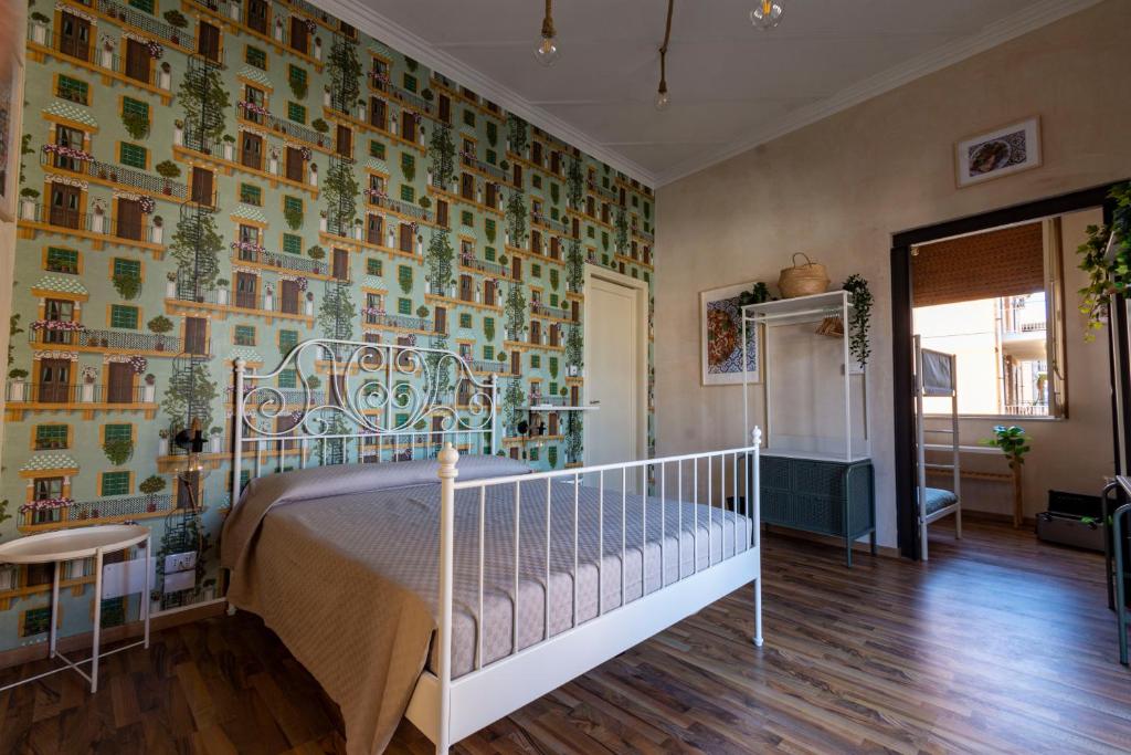 een slaapkamer met een bed en een kleurrijke muur bij Locanda Popolare in Aci Castello