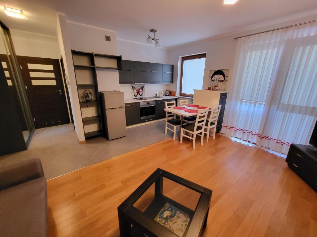 a kitchen and a living room with a table and chairs at Apartament Centrum in Iława