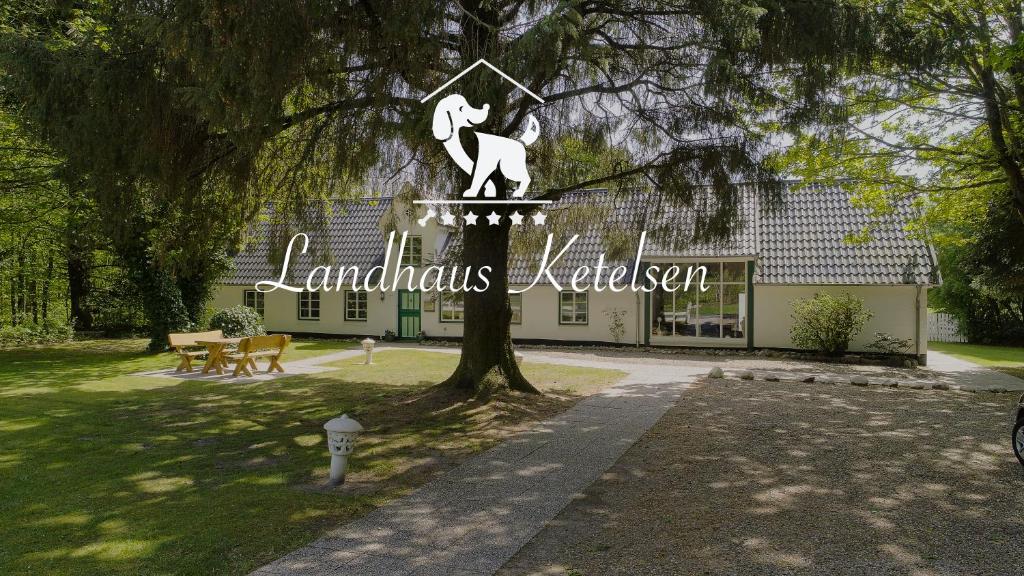 un edificio con un cartel delante de un árbol en Landsitz Braderup Festland, en Braderup