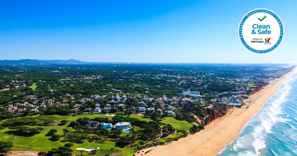 una vista aerea sulla spiaggia con logo di sicurezza sull'oceano di Vale Do Lobo Resort a Vale do Lobo