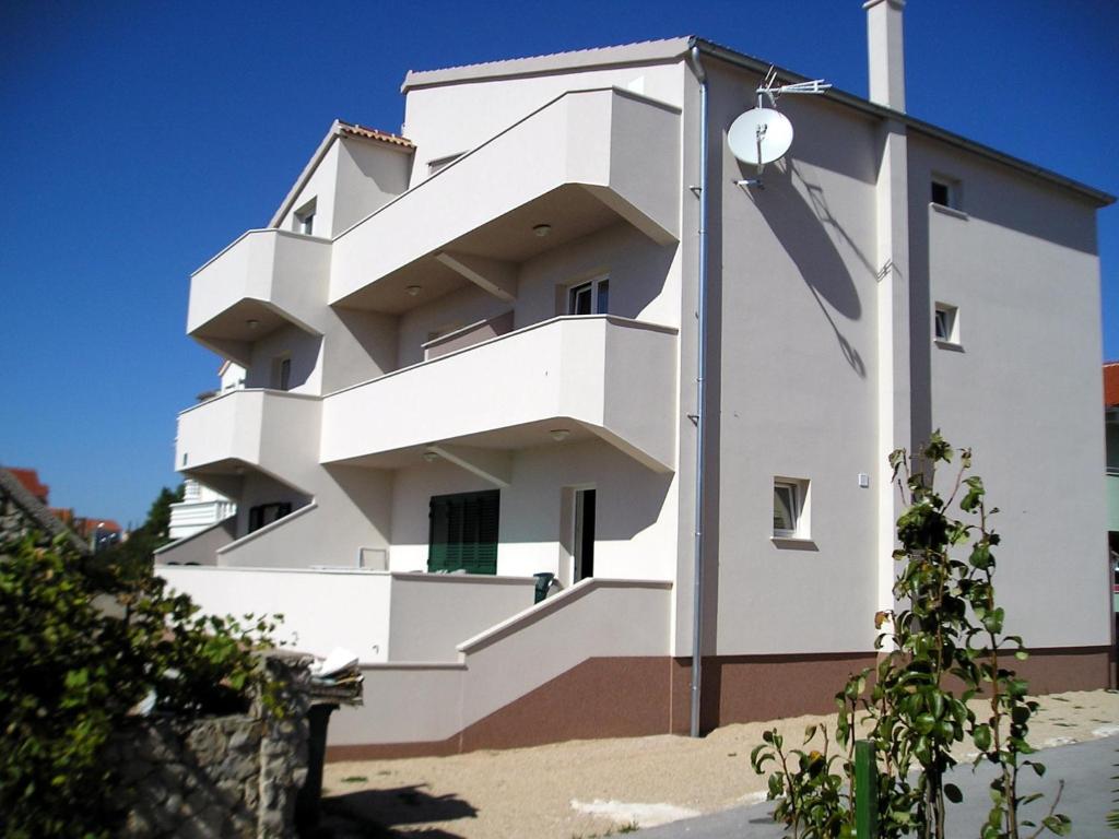 un edificio blanco con escaleras laterales en Apartments Josipa & Niki, en Vodice