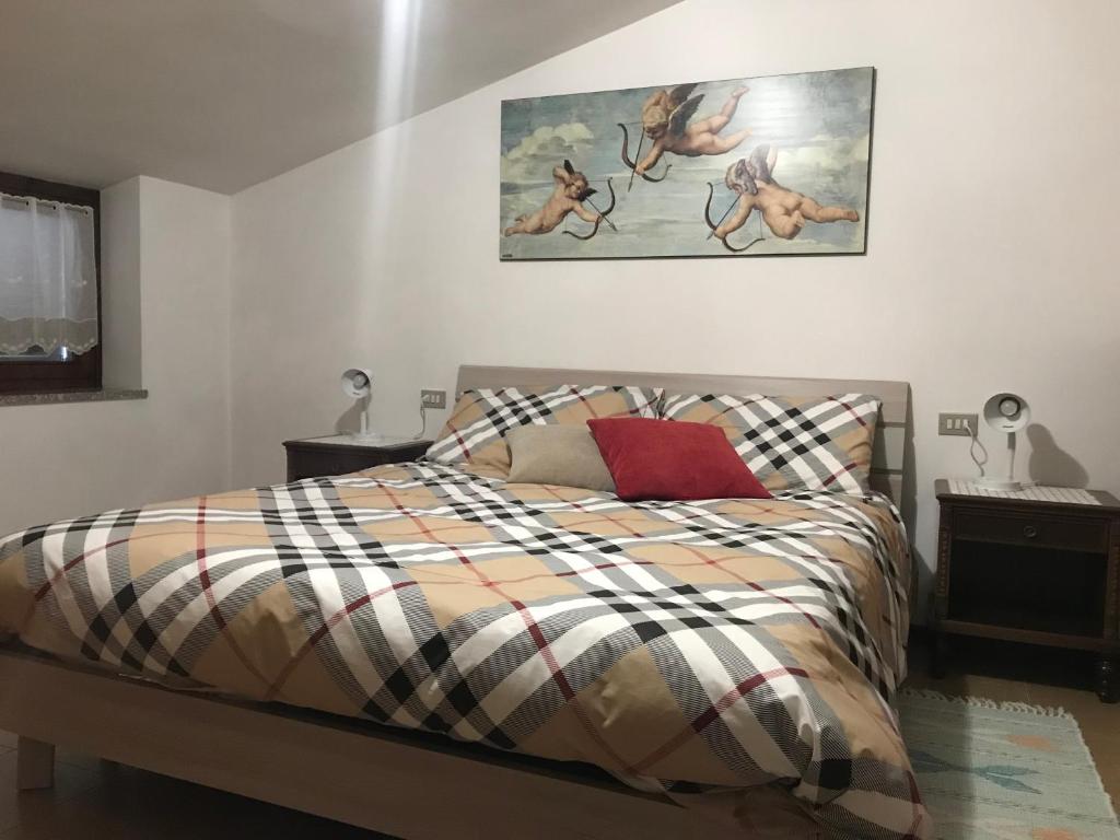 a bedroom with a bed and a painting on the wall at B&B Bunela in Volpino