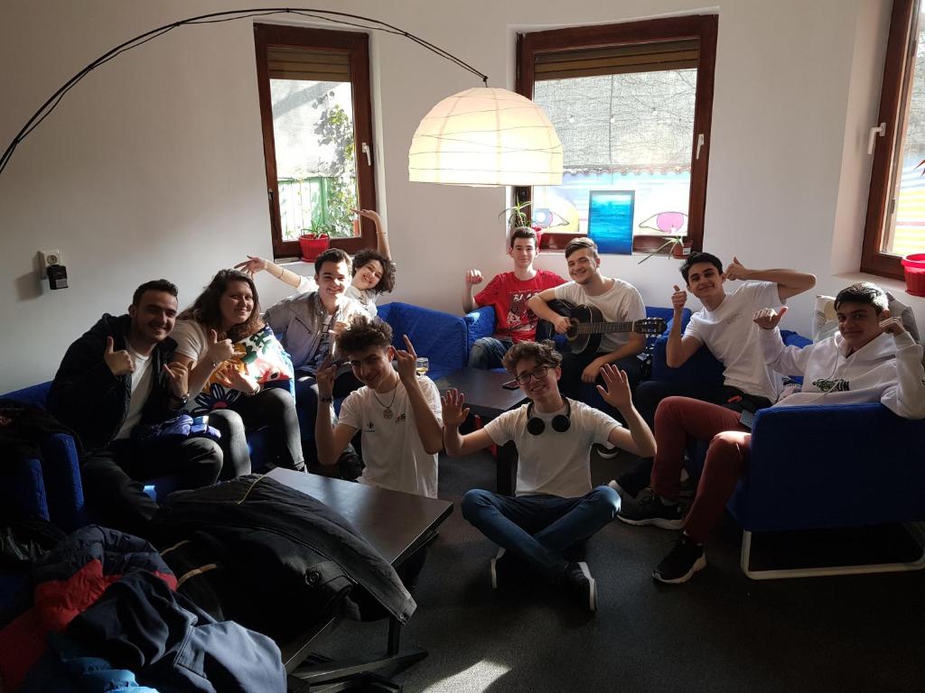 un gruppo di persone seduti in un soggiorno di Popcorn Hostel a Bucarest