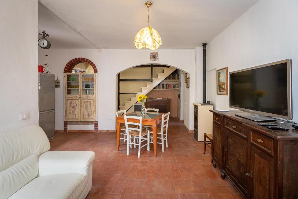 a living room with a television and a table with chairs at Casa Max - Venturina Terme in Campiglia Marittima