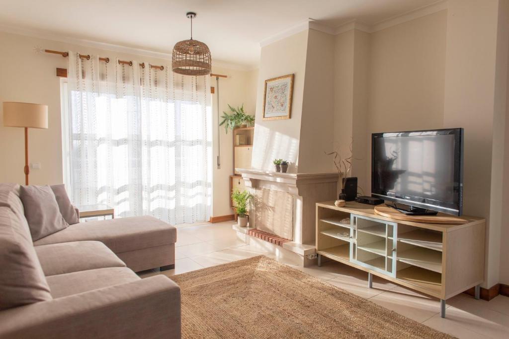 ein Wohnzimmer mit einem Sofa und einem Flachbild-TV in der Unterkunft Middle of the bay 2 bedroom apartment in Ferrel