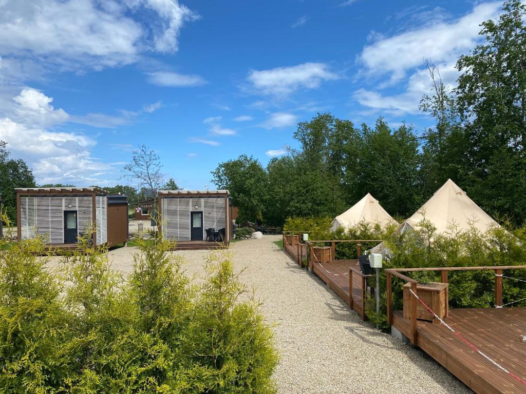 a group of tents in a garden with trees at Mereoja Camping in Kõrkküla