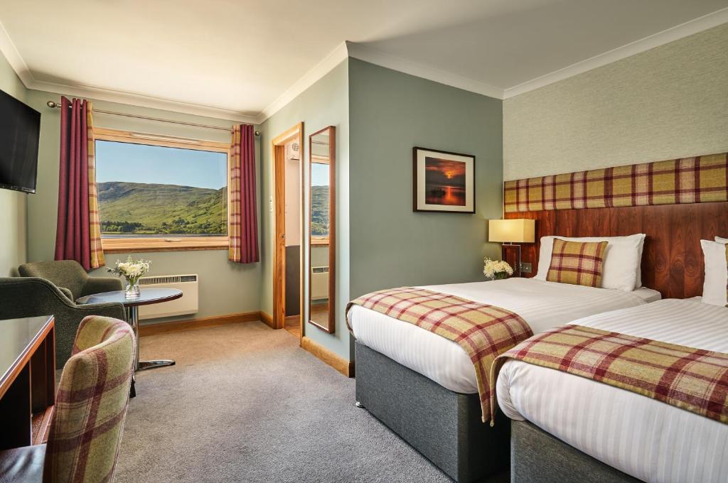 Postel nebo postele na pokoji v ubytování Clan Macduff Hotel
