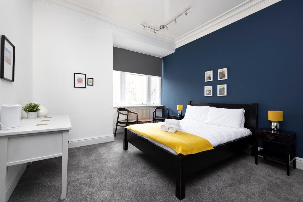 1 dormitorio con cama y pared azul en ALTIDO Haymarket, en Edimburgo