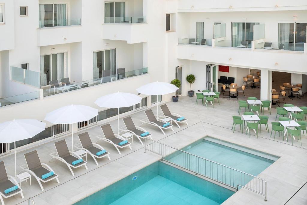 een uitzicht over het zwembad en de patio van een hotel bij Aparthotel Marina Drach in Porto Cristo