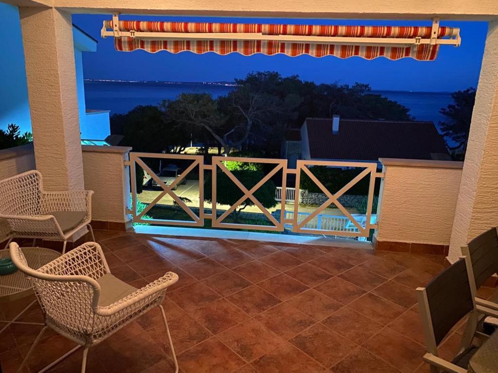 a patio with chairs and a view of the ocean at Apartments Kosljun 123 in Košljun