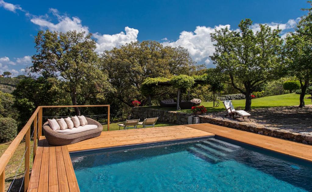 a swimming pool with a wooden deck next to at Country Relais La Mortella in Porto Ercole