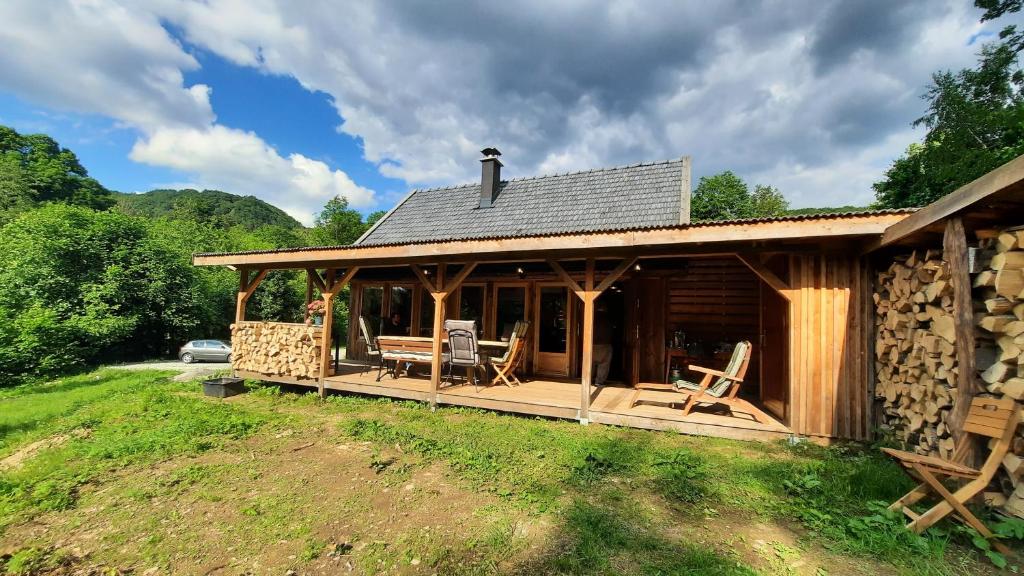 eine Blockhütte mit einer Terrasse und Stühlen darauf in der Unterkunft Kura pod Złotym Kogutem in Kudowa-Zdrój