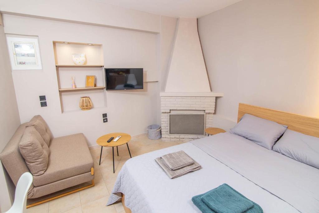 a bedroom with a bed and a chair and a fireplace at Le Magne Apartments Kardamili in Kardamili