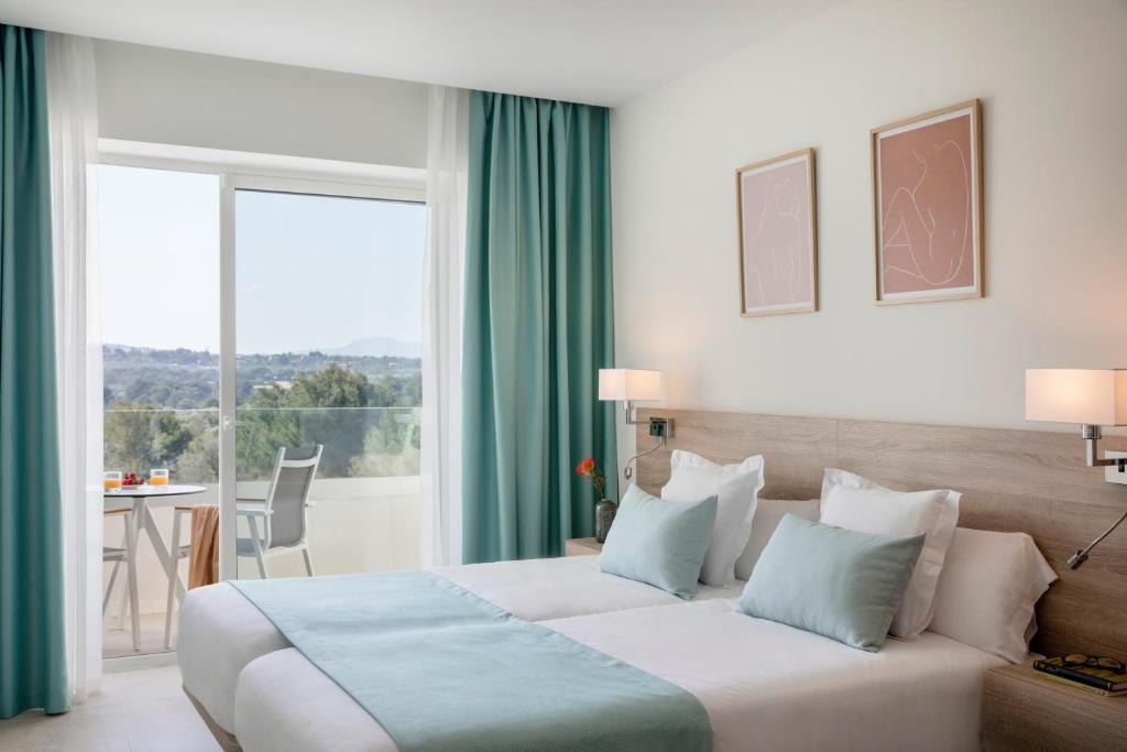 a hotel room with a bed and a large window at Aparthotel Marina Drach in Porto Cristo