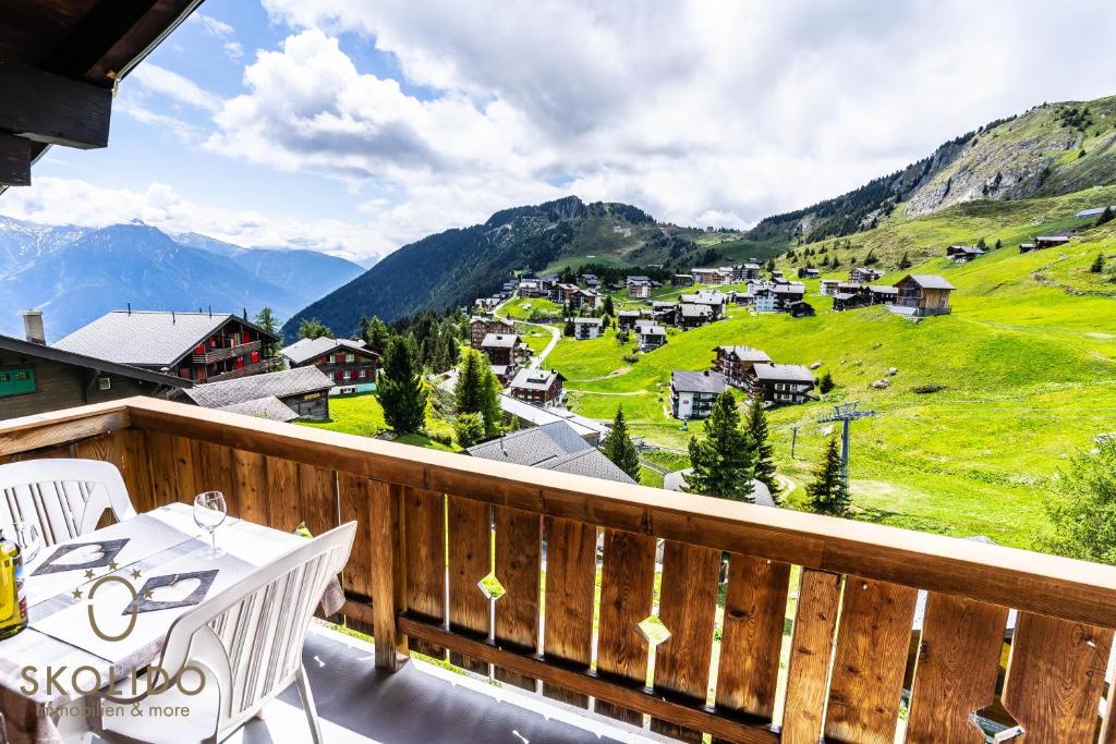 een balkon met een tafel en stoelen en bergen bij Haus Alpsegen, Riederalp Alpsegen Riederalp in Riederalp
