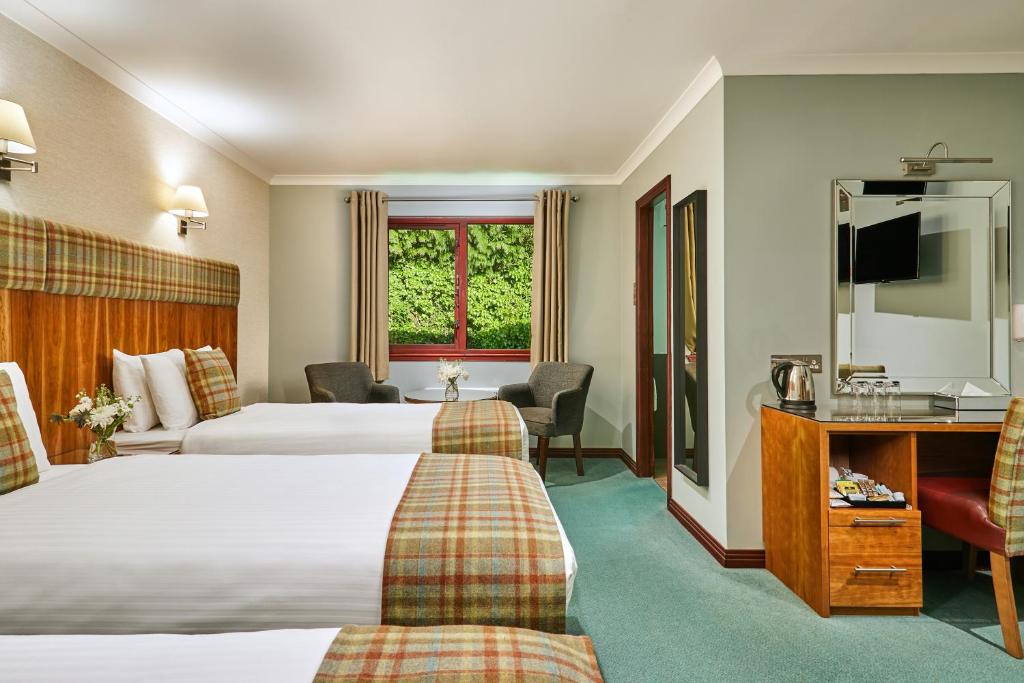 Postel nebo postele na pokoji v ubytování Clan Macduff Hotel