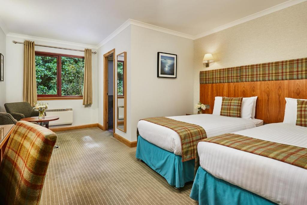 Postel nebo postele na pokoji v ubytování Clan Macduff Hotel