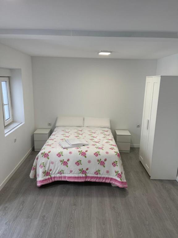 Dormitorio blanco con cama con manta rosa en Apto Pradolongo, en Madrid