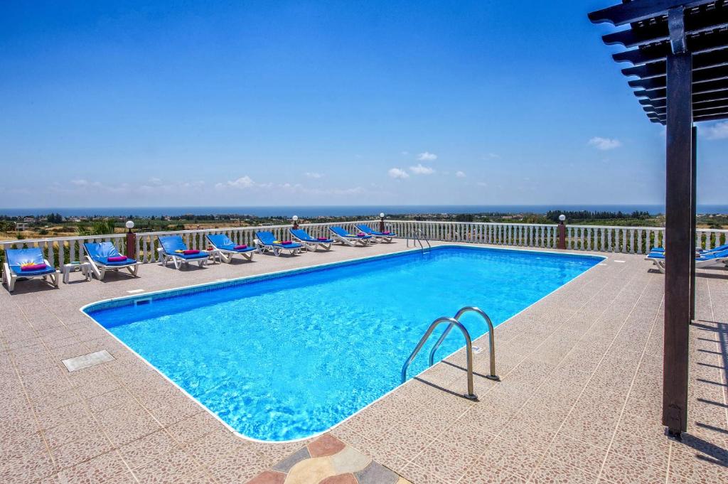 - une piscine avec des chaises et une vue sur l'océan dans l'établissement Villa Veronika by Villa Plus, à Peyia