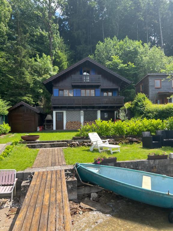 a house with a boat in front of it at Haus am See in Henndorf am Wallersee