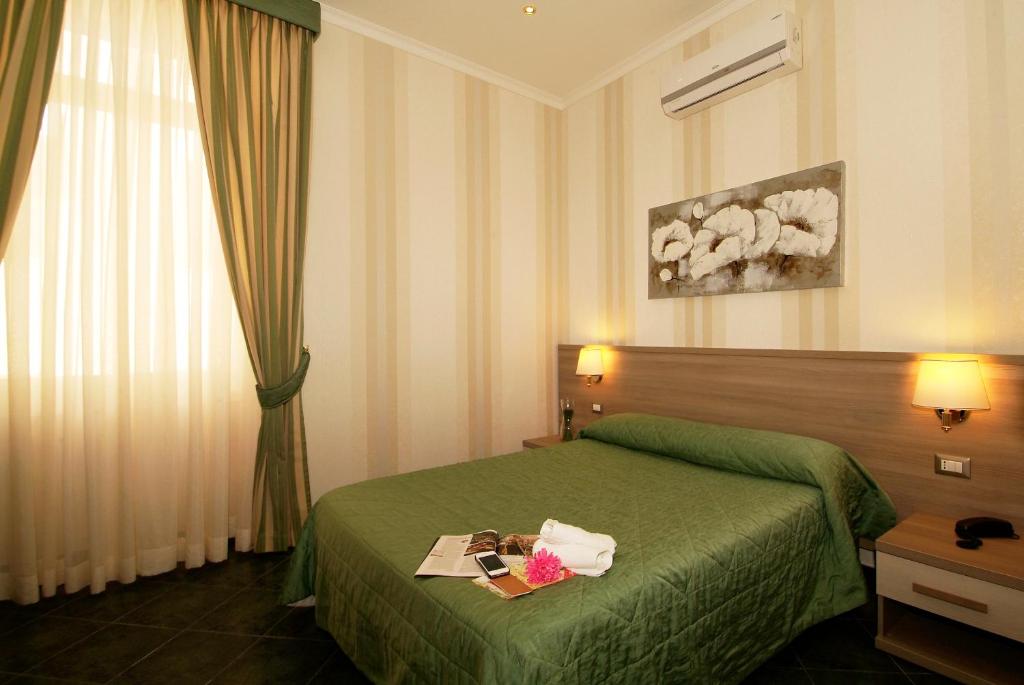 Habitación de hotel con cama verde y ventana en Hotel Argentina, en Roma