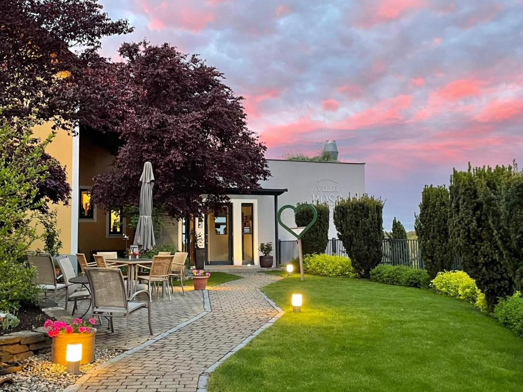 eine Terrasse mit einem Tisch und Stühlen im Hof in der Unterkunft Hotel Villa Rosa in Gamlitz