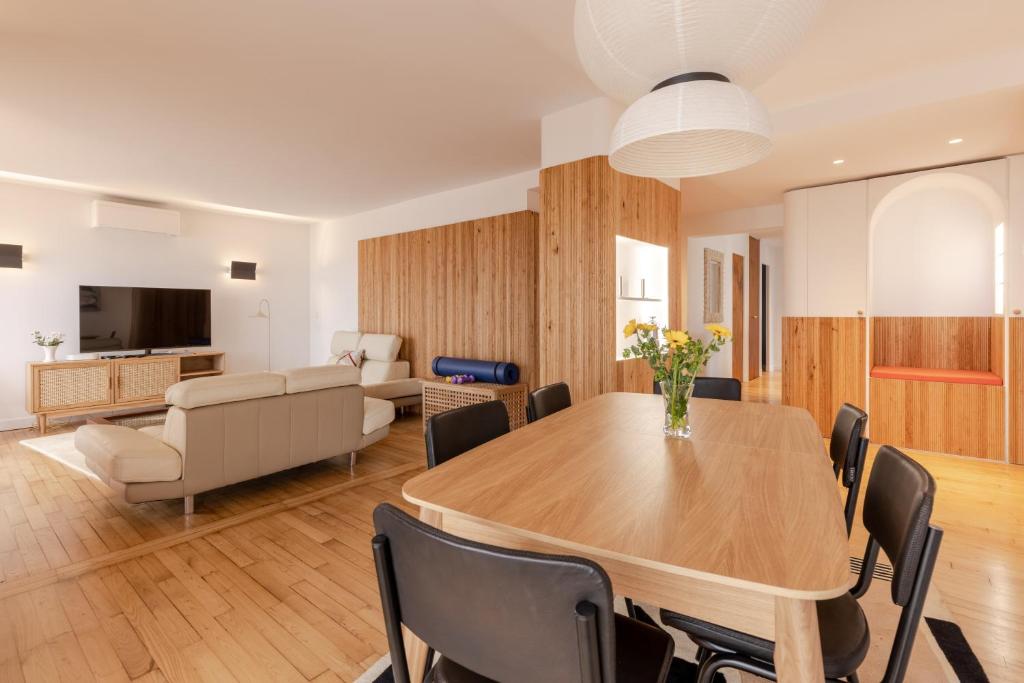 een eetkamer met een tafel en een woonkamer bij La Perrinière appartement face mer in Royan