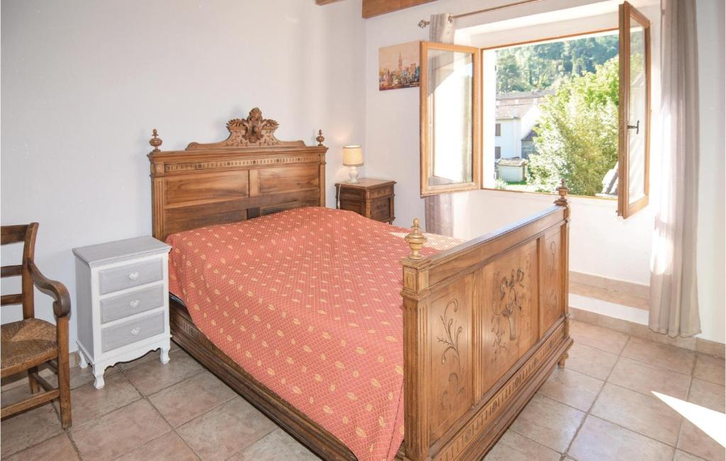 a bedroom with a wooden bed and a window at Awesome Home In Bessges With Wifi in Bessèges