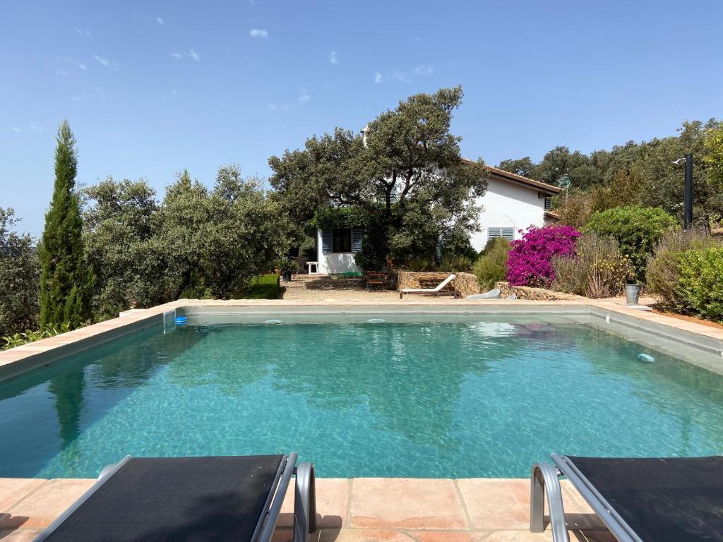 una piscina de agua azul en un patio en Casa Rural La Alcornocosa, en El Castillo de las Guardas