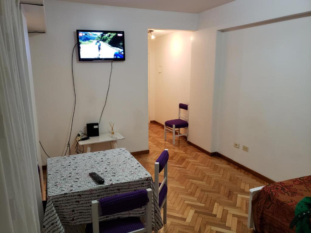 a room with a table and a television on a wall at Amusing Apartment Recoleta in Buenos Aires