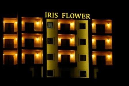 um edifício de apartamentos iluminado com as palavras atingem a flor em Iris Flower Hotel em Jezzine