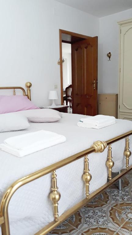 two beds with white sheets and gold rails in a bedroom at Location Serafina Pennapiedimonte in Pennapiedimonte