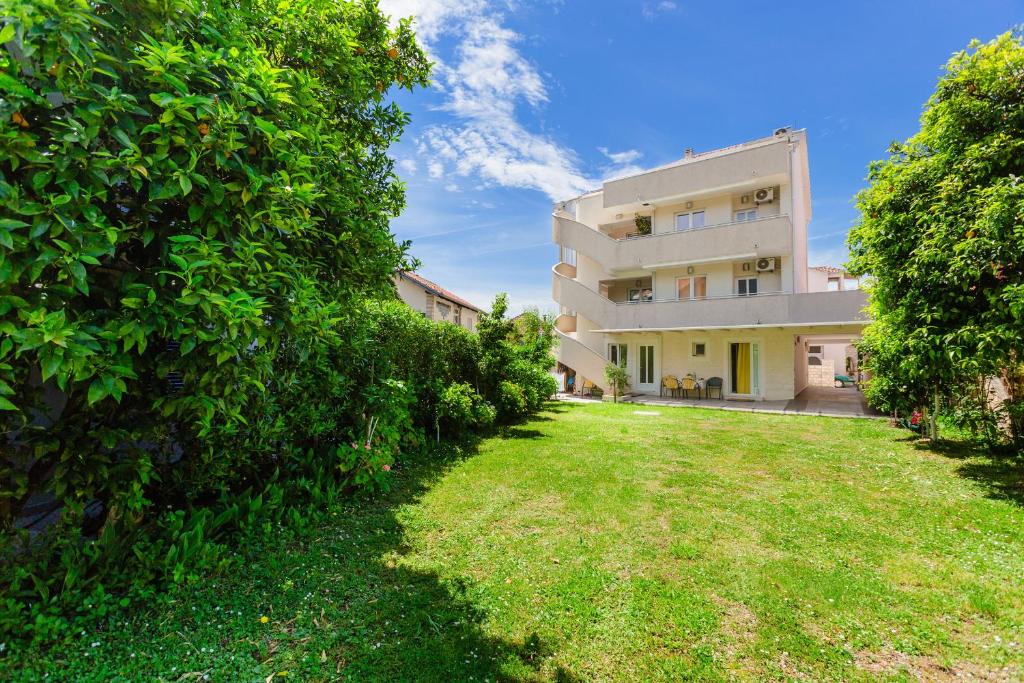 an exterior view of a building with a yard at Rosic Apartments Tivat in Tivat