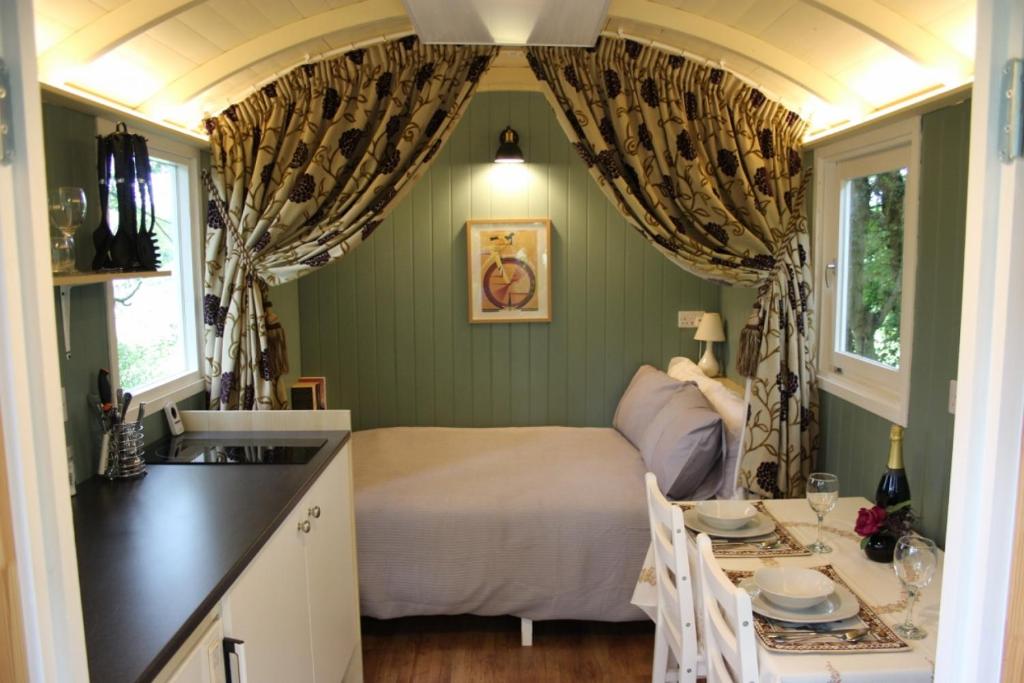 a kitchen with a bed and a sink in a room at The Kestrel Shepherd Hut, Whitehouse Farm in Stowmarket
