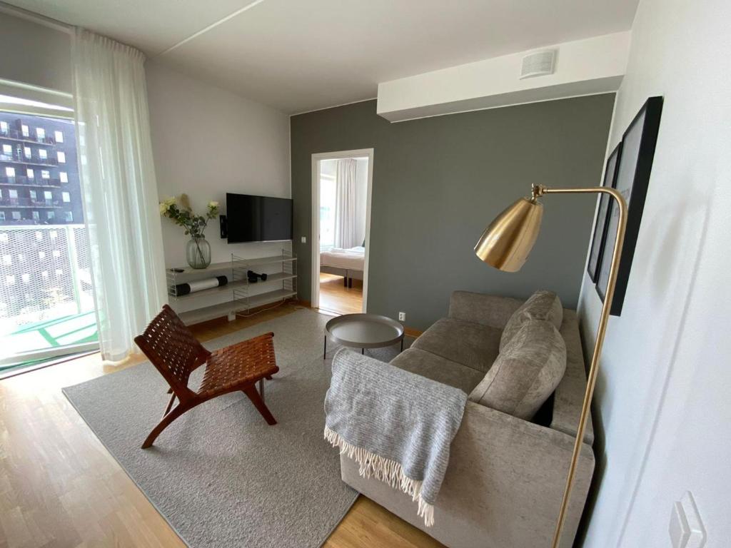 ein Wohnzimmer mit einem Sofa und einem Stuhl in der Unterkunft Luxury Business Apartments 2 rooms #2 1-4 people in Sundbyberg