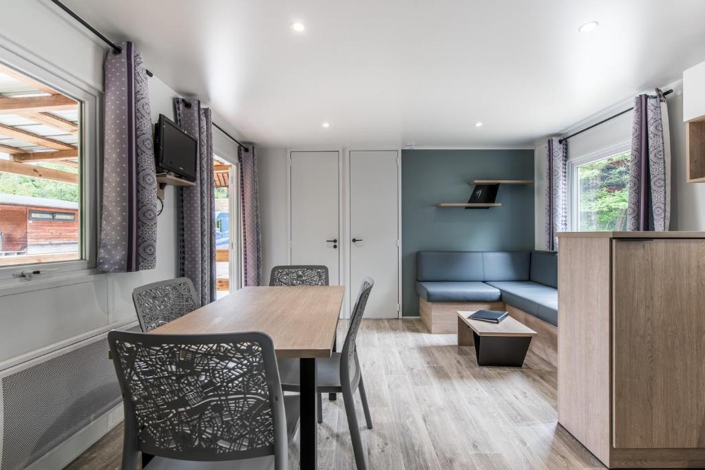 una sala da pranzo e un soggiorno con tavolo e sedie di Les Mobil-homes By Le Marintan a Saint-Michel-de-Maurienne