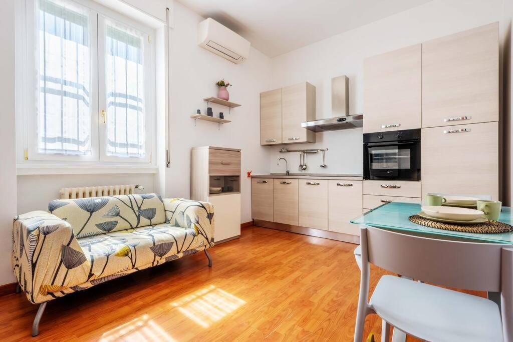 uma sala de estar com um sofá e uma mesa em Cozy apartament in Piazza 5 Giornate by Easylife em Milão