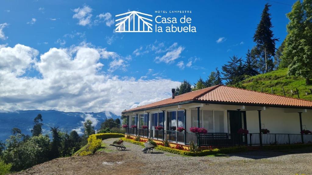 a house on a hill with mountains in the background at Hotel Campestre Casa de la Abuela in La Capilla