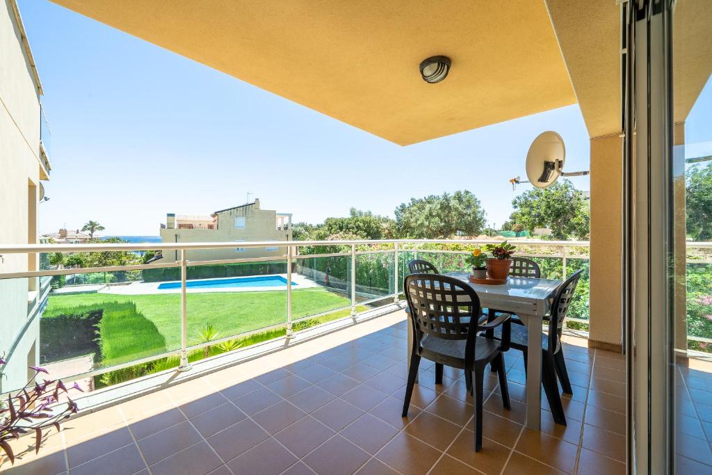 a patio with a table and chairs on a balcony at Hauzify I Apartament Cala Pepo 1 in L'Ametlla de Mar